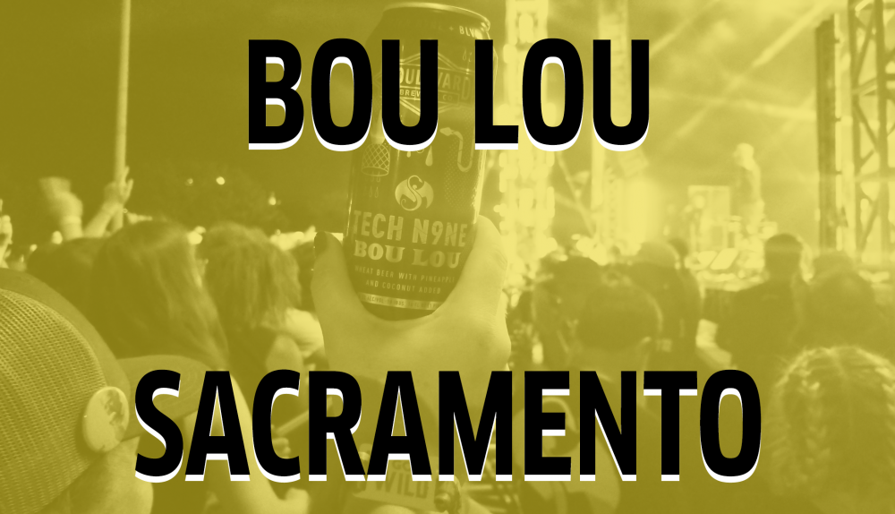 A can of "Bou Lou" is held up by someone in a crowd at an event in Sacramento. The scene is set at night, with stage lights visible in the background. The image has a yellow tint.