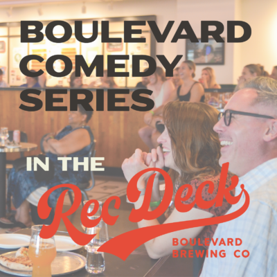 A lively audience enjoys a comedy show at a brewery. The text "Boulevard Comedy Series in the Rec Deck" overlays the image, with "Boulevard Brewing Co" also mentioned. People are smiling and laughing, creating a joyful and engaging atmosphere.