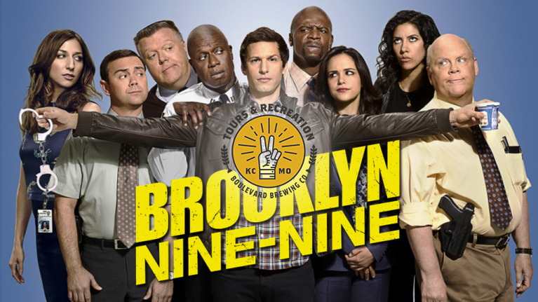 The image shows a diverse group of nine characters from the TV show "Brooklyn Nine-Nine," all dressed in police attire, standing together. One person extends a finger, pointing outward. The show's title is prominently displayed in bold yellow text.
