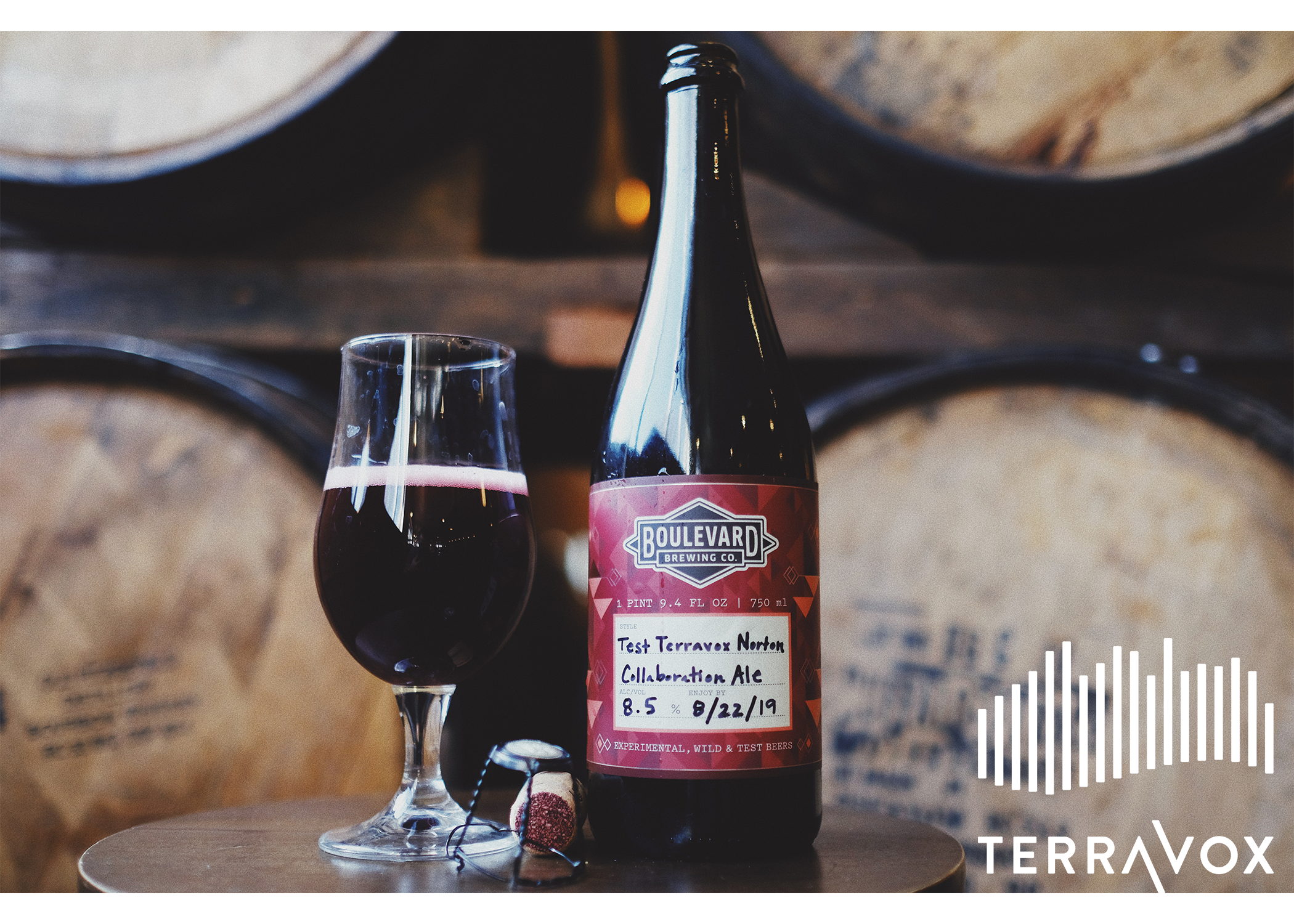 A bottle and glass of red ale sit on a wooden table against a backdrop of wooden barrels. The label on the bottle reads "Boulevard Brewing Co. Collaboration Ale" with a date of 8/22/19. The lower right corner displays the TerraVox logo.