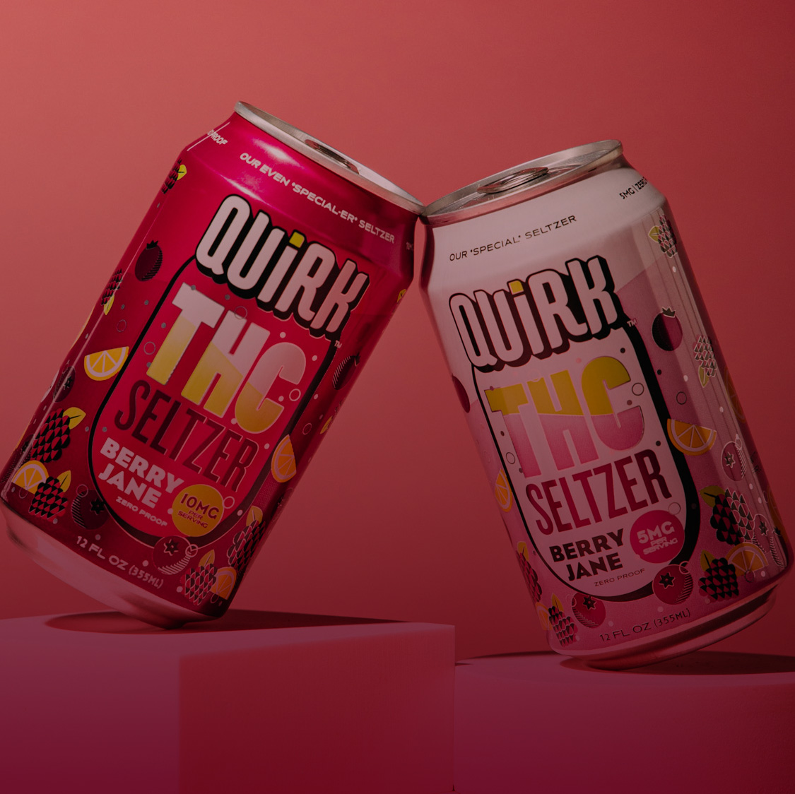 Two colorful cans of Quirk THC Seltzer from Boulevard Brewing Co., Kansas City, Missouri, in "Berry Jane" flavor, lean together on a pink surface. The cans showcase fruit illustrations and bold THC seltzer branding.