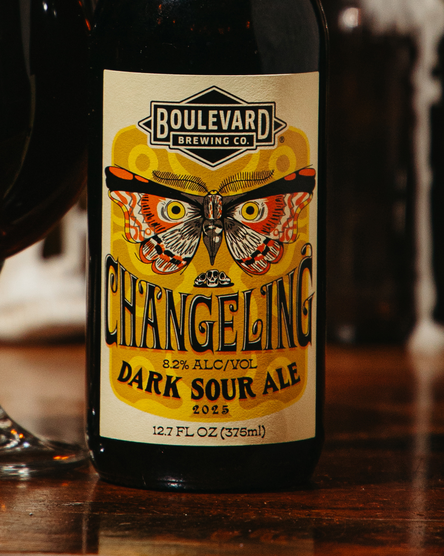A bottle of Boulevard Brewing Co. Changeling Dark Sour Ale, 8.2% ABV, with a colorful moth illustration on the label. The label also shows the year 2025 and the volume as 12.7 fl oz (375 ml).
