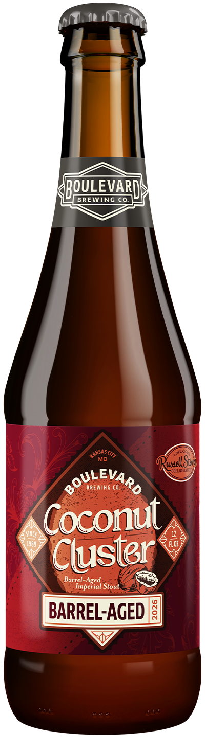 A brown glass bottle of Boulevard Brewing Co. Coconut Cluster Barrel-Aged Stout with a red label, showcasing brewery and beer name, and a small Russell Stover logo.