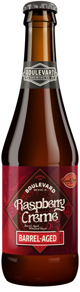 A brown glass bottle of Boulevard Brewing Co. Raspberry Crème Barrel-Aged Wheated Stout. The label is deep red with a vintage design, featuring the text "Raspberry Crème" and a "Russell Stover Collaboration" logo.