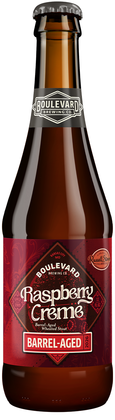 A brown glass bottle of Boulevard Brewing Co. Raspberry Crème Barrel-Aged Wheated Stout. The label is deep red with a vintage design, featuring the text "Raspberry Crème" and a "Russell Stover Collaboration" logo.
